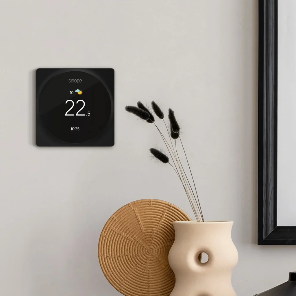 Thermostat intelligent Sinopé mural noir dans un salon
